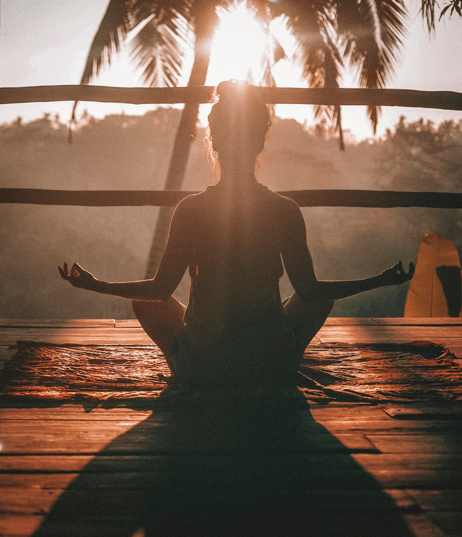 Persona meditando al amanecer frente a la naturaleza